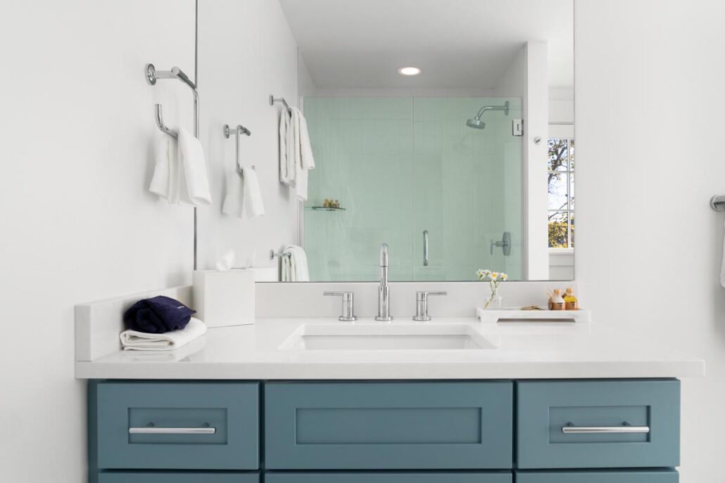 Bathroom vanity with sink and mirror showing stand up shower