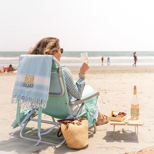 Woman sitting on the beach with glass of wine